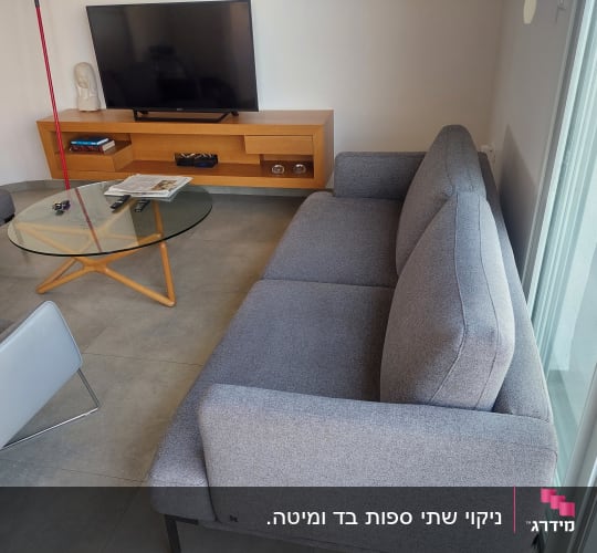 ספה אפורה ליד חלון זכוכית בסלון מודרני